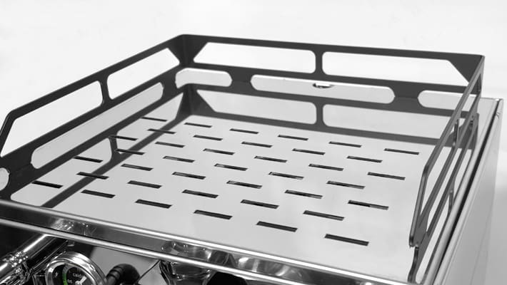 A close-up of the stainless steel cup warmer tray with horizontal slots and raised sides on the Bezzera Luce HX Espresso Machine, designed to hold cups above the machine.
